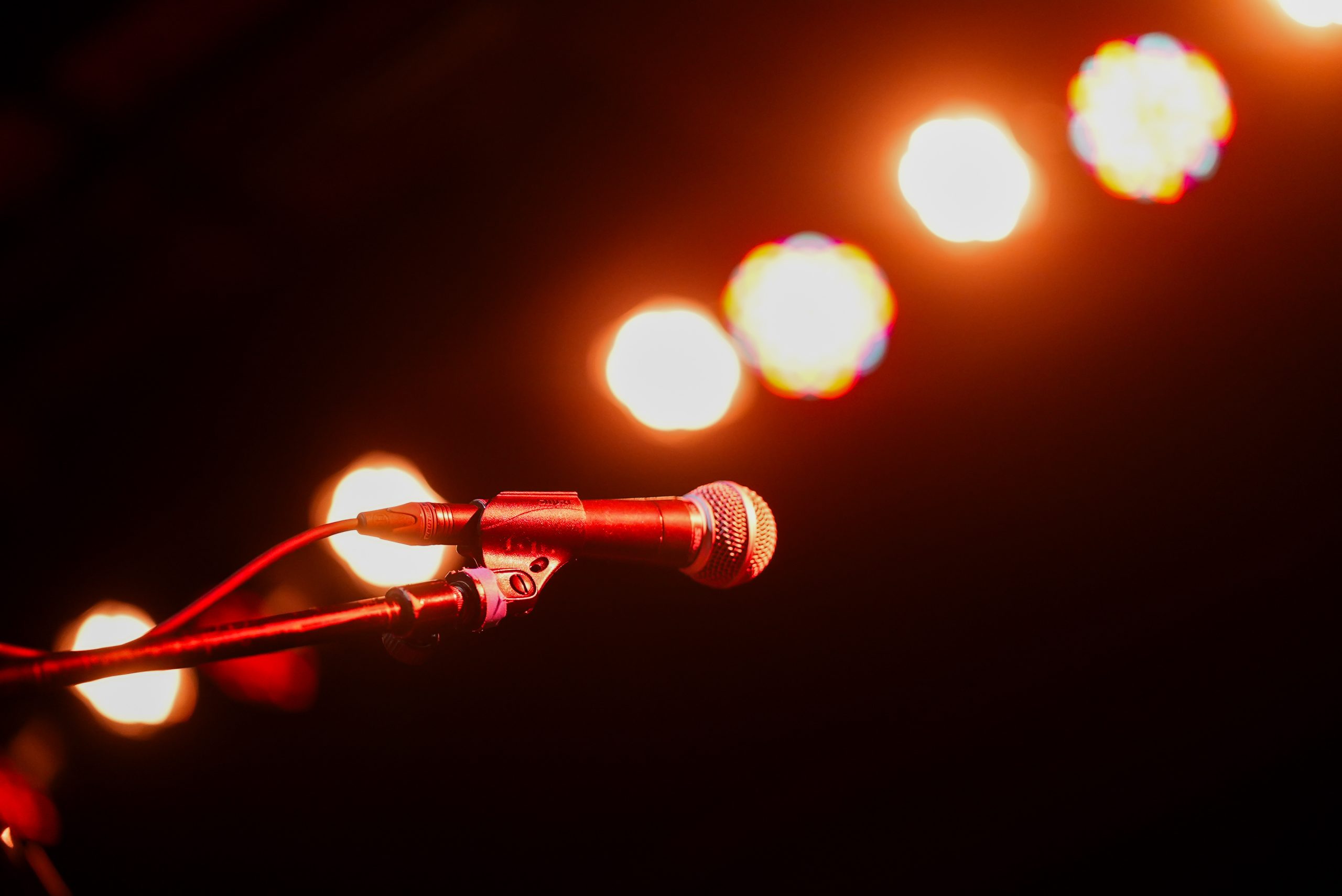 Microphone illuminated by stage lighting before a live performance.